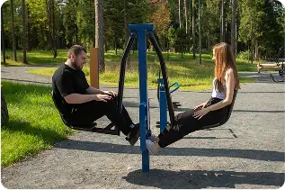 Two adults using outdoor exercise equipment during a community-based ABA session in Wake County, NC